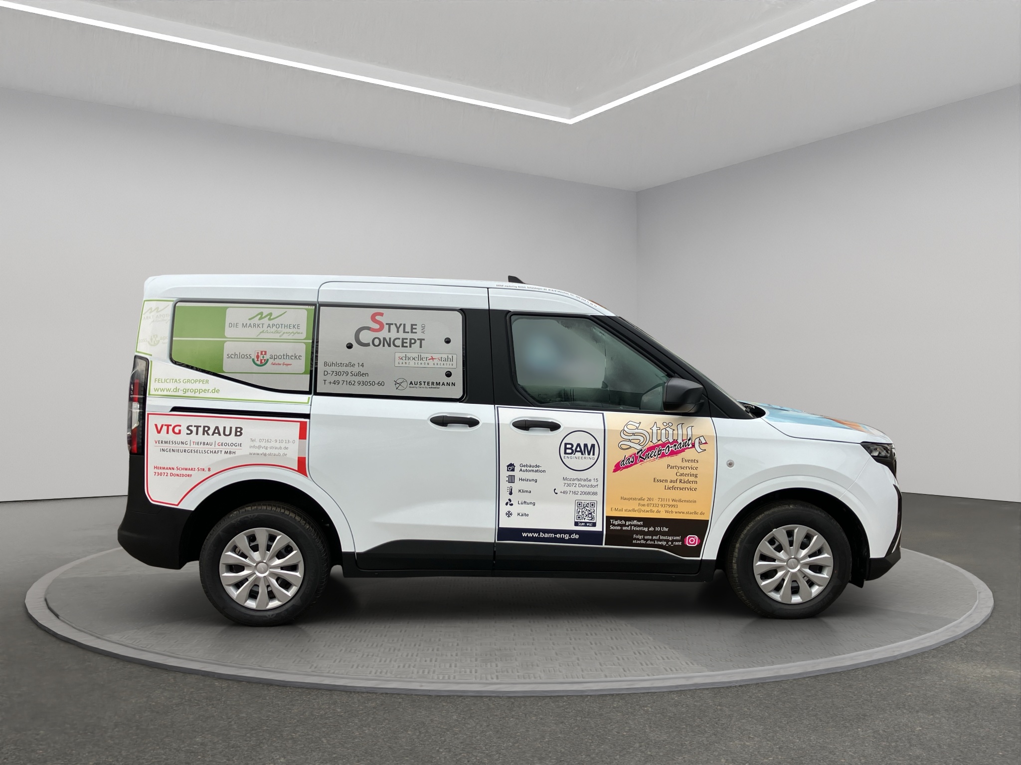 Transporter mit mehreren Werbeflächen steht in einer hellen Halle